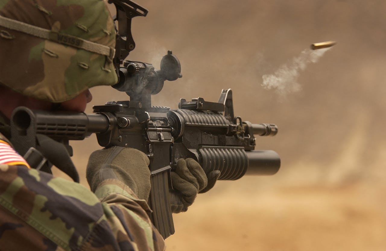 who-we-are Close-up of a soldier in camo firing a rifle in action during training.